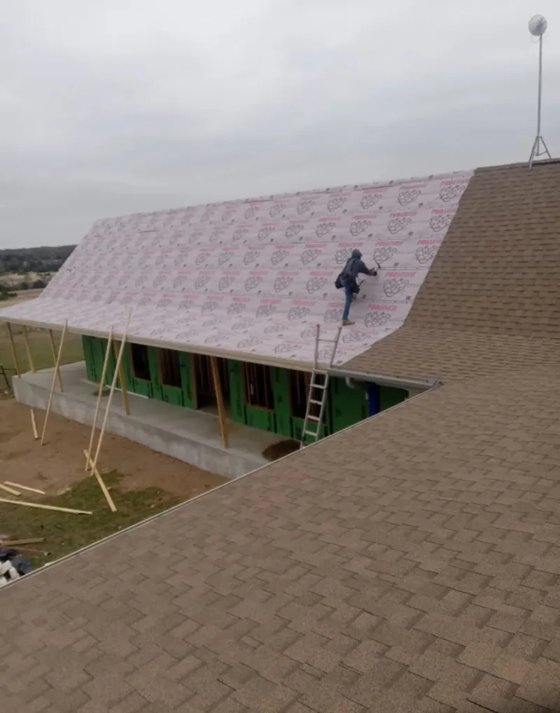 Worker preparing underlayment for a metal roof installation in Lake Stickney